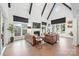 Bright living room with hardwood floors, vaulted ceiling, dark beams and large windows for an abundance of natural light at 1711 Brook Rd, Charlotte, NC 28205