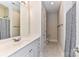 Well-lit bathroom featuring a vanity with white cabinets, a framed mirror, and a shower with a blue patterned curtain at 178 Harper Lee St, Davidson, NC 28036