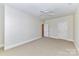 Spacious bedroom featuring neutral walls, carpeting, white trim and two entry doors at 178 Harper Lee St, Davidson, NC 28036
