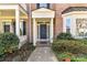 Inviting home entrance showcases a classic blue door with white trim, surrounded by lush landscaping at 178 Harper Lee St, Davidson, NC 28036