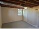 Basement featuring painted walls and floor, exposed wooden beams, and a window at 1873 Rocky River Rd, Lancaster, SC 29720