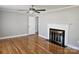 Cozy living room features gleaming hardwood floors, a ceiling fan, and a fireplace at 1873 Rocky River Rd, Lancaster, SC 29720