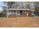 Inviting single story home with a brick facade and covered front porch, offering a cozy curb appeal at 208 Tomberlin Rd, Mount Holly, NC 28120