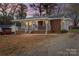 Charming single story home with brick and siding, a covered front porch, and mature trees at 208 Tomberlin Rd, Mount Holly, NC 28120
