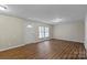 The open living room shows the large window, neutral walls and hardwood flooring at 208 Tomberlin Rd, Mount Holly, NC 28120