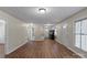 Open-concept living room with hardwood floors, neutral walls, and access to the kitchen and bedrooms at 208 Tomberlin Rd, Mount Holly, NC 28120