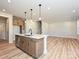 Open kitchen layout with island, wood floors, and modern light fixtures at 209 Halemarg Dr, Belmont, NC 28012