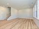 Bright living room featuring hardwood floors, a staircase, and large windows for natural light at 209 Halemarg Dr, Belmont, NC 28012