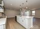 Open-concept kitchen with quartz island, stainless appliances, and wood floors flowing into the living area at 211 Halemarg Dr, Belmont, NC 28012