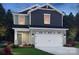 Two-story home features a stone-accented garage, light green siding, and stylish dark gray upper level shingles at 213 Alden Ct, Shelby, NC 28152