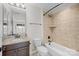 Bathroom featuring granite counters, dark cabinets, and a tiled shower/tub at 225 Lincoln St, Charlotte, NC 28203