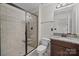 Bathroom featuring granite counters, dark cabinets, and a glass-enclosed shower at 225 Lincoln St, Charlotte, NC 28203