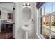 Powder room with pedestal sink, oval mirror, and natural light at 225 Lincoln St, Charlotte, NC 28203