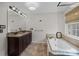 Bright bathroom featuring double vanity with granite counters and a separate tub with glass door at 225 Lincoln St, Charlotte, NC 28203