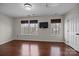 Bedroom with three windows, wood floors, and a wall-mounted television at 225 Lincoln St, Charlotte, NC 28203