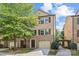 Charming brick two-story townhouse with attached garage, beautiful tree, and manicured front yard at 225 Lincoln St, Charlotte, NC 28203