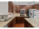 Kitchen featuring stainless steel appliances, stone countertops, dark wood cabinets, and hardwood floors at 225 Lincoln St, Charlotte, NC 28203