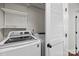 Bright laundry room featuring modern white appliances and ample shelving for storage at 225 Lincoln St, Charlotte, NC 28203