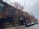 Street view of brick building with blooming trees and a row of parked cars at 225 Lincoln St, Charlotte, NC 28203