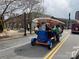 View of group on Trolley Pub driving on city street with buildings in the background at 225 Lincoln St, Charlotte, NC 28203