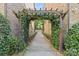 Arched wooden trellis covered in ivy leads to a walkway between two brick buildings at 225 Lincoln St, Charlotte, NC 28203