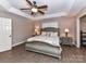 Spacious bedroom with a ceiling fan, tray ceiling, hardwood floors, and large windows at 2553 Willowbrook Dr, Matthews, NC 28104