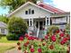 Two-story home with red roof, white trim, large front porch, and blooming red roses at 322 4Th Sw St, Hickory, NC 28602