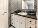 Half-bath with black and white patterned wallpaper, white vanity and black countertop at 406 Forest Dr, York, SC 29745