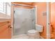 Bathroom featuring a clear glass shower door, toilet, and coral colored walls at 406 Forest Dr, York, SC 29745