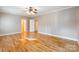 Light filled bedroom with hardwood floors, gray walls, white trim, and access to closets and hallway at 406 Forest Dr, York, SC 29745