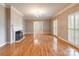 Spacious living room featuring a cozy fireplace, shuttered windows, and gleaming hardwood floors at 406 Forest Dr, York, SC 29745