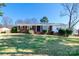 Charming single-story brick home featuring a well-manicured lawn and mature landscaping at 601 Carole Ln, Charlotte, NC 28214