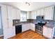 Bright kitchen featuring white cabinetry, modern stainless steel appliances, and a tiled backsplash at 601 Carole Ln, Charlotte, NC 28214