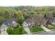 An aerial view of a suburban home with a well-kept lawn, an orange front door, and surrounding green trees at 6319 High Creek Ct, Charlotte, NC 28277