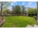 Large backyard with lush green grass and a rustic wooden fence at 6319 High Creek Ct, Charlotte, NC 28277