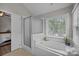 Bathroom featuring a large soaking tub, shower, and large window with natural lighting at 6319 High Creek Ct, Charlotte, NC 28277