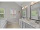 Bright bathroom featuring double sinks, tile floors, and a large window for natural light at 6319 High Creek Ct, Charlotte, NC 28277