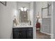 Powder room featuring a black vanity with sink, framed mirror, and modern fixtures at 6319 High Creek Ct, Charlotte, NC 28277