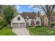 Charming two-story home with a well-manicured lawn, two-car garage, and inviting orange front door at 6319 High Creek Ct, Charlotte, NC 28277