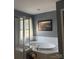 Bathroom featuring an oval soaking tub with tiled surround and shower with glass doors, plus natural lighting at 6410 Hasley Woods Dr, Huntersville, NC 28078