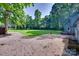 Expansive backyard featuring a gravel patio, lush green lawn, and mature trees at 6688 Pine Forest Dr, York, SC 29745