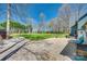 Scenic backyard with large green lawn, lush trees, gravel patio, and a cozy seating area on the deck at 6688 Pine Forest Dr, York, SC 29745