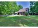 Inviting home exterior with a wide, green lawn and a covered front porch amidst lush trees at 6688 Pine Forest Dr, York, SC 29745