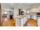 Spacious kitchen with island, stainless appliances, granite counters, white cabinets, and hardwood floors at 6688 Pine Forest Dr, York, SC 29745