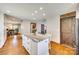 Bright, open kitchen with island, white cabinets, granite counters, stainless fridge and hardwood floors at 6688 Pine Forest Dr, York, SC 29745
