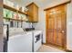 Functional laundry room with washer, dryer, wood cabinets, shelves and wood door at 6688 Pine Forest Dr, York, SC 29745