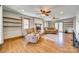 Bright living room featuring hardwood floors, brick fireplace, ceiling fan, and access to outdoor spaces at 6688 Pine Forest Dr, York, SC 29745
