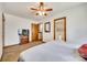 Bright main bedroom featuring a ceiling fan, TV on shelving, and entry to a bathroom at 6688 Pine Forest Dr, York, SC 29745