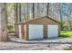 Metal storage building with two garage doors and a side entry door with gravel driveway at 6688 Pine Forest Dr, York, SC 29745