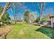 A spacious backyard includes a wooden deck, outdoor seating, mature trees and a lush lawn at 6956 Oakstone Pl, Charlotte, NC 28210